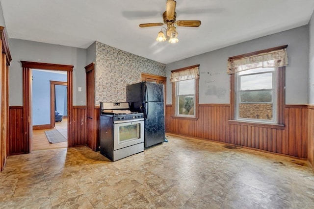 14 Halmstad, Worcester, MA 01607 - kitchen with stainless steel range with gas cooktop, a wainscoted wall, freestanding refrigerator, ceiling fan, and wooden walls