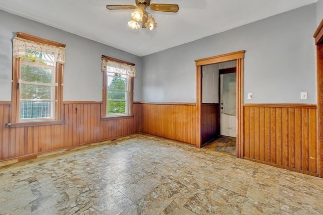 14 Halmstad, Worcester, MA 01607 - unfurnished room featuring a wainscoted wall, ceiling fan, wooden walls, and stone finish flooring