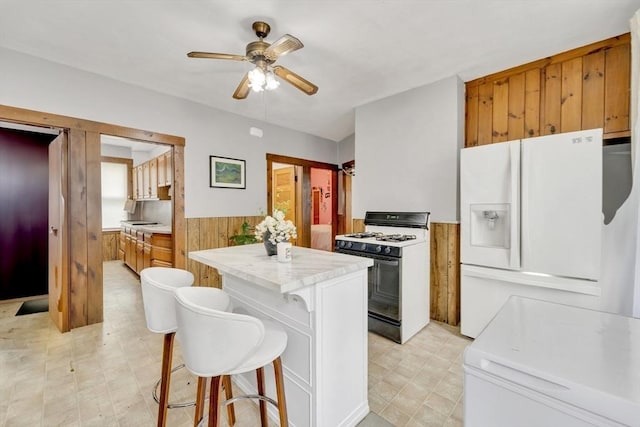 14 Halmstad, Worcester, MA 01607 - kitchen featuring range with gas stovetop, white fridge with ice dispenser, ceiling fan, a wainscoted wall, and light countertops