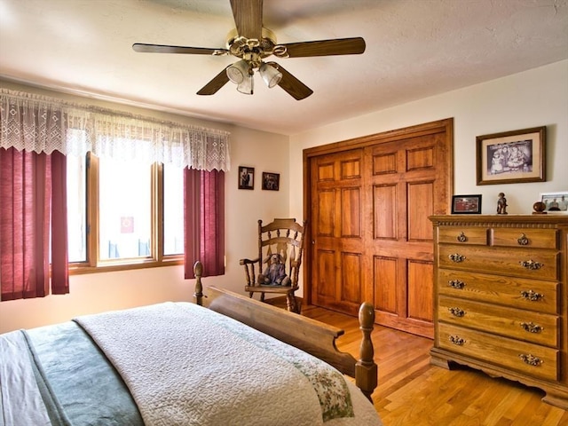 bedroom featuring wood finished floors, ceiling fan, and a closet