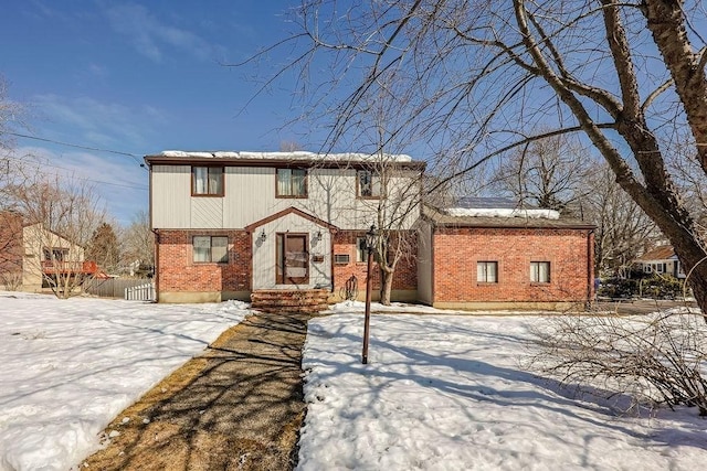 colonial home featuring brick siding and fence