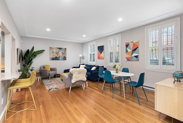 living room featuring baseboard heating, recessed lighting, and light wood-type flooring