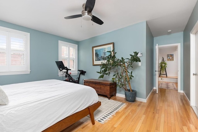 bedroom with light wood-type flooring, baseboards, and a ceiling fan