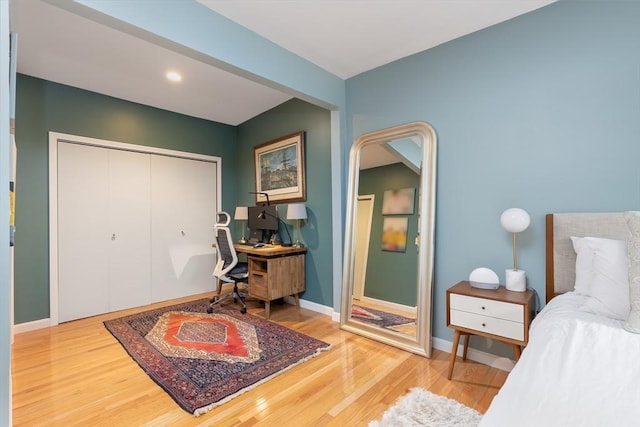 bedroom featuring a closet, baseboards, and wood finished floors