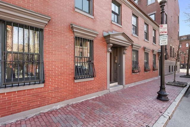 doorway to property featuring brick siding