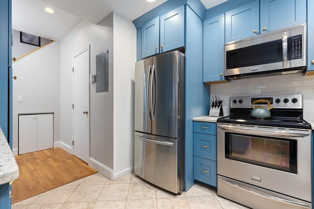 kitchen featuring blue cabinets, stainless steel appliances, light countertops, light tile patterned floors, and decorative backsplash