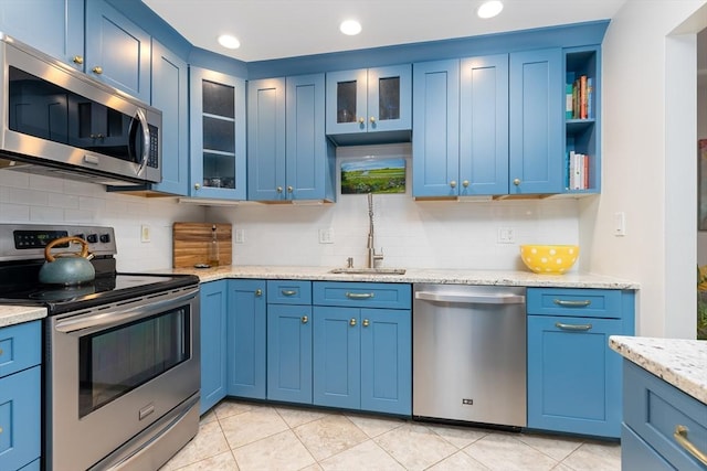 kitchen featuring light tile patterned floors, decorative backsplash, stainless steel appliances, and blue cabinets