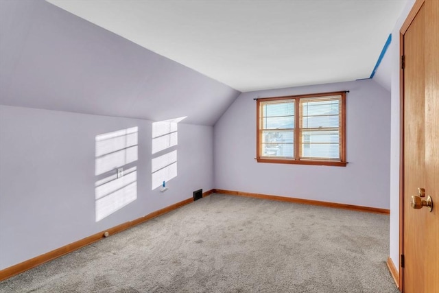 bonus room featuring vaulted ceiling and carpet