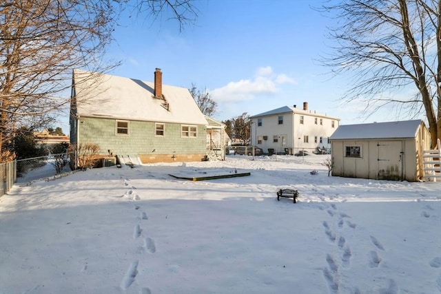 snow covered property with a shed