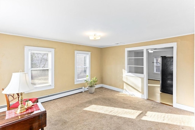 carpeted empty room with a healthy amount of sunlight, crown molding, and a baseboard heating unit