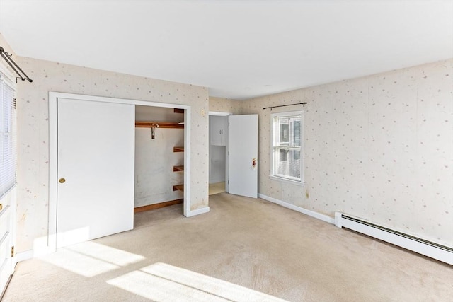 unfurnished bedroom featuring baseboard heating, a closet, and light colored carpet