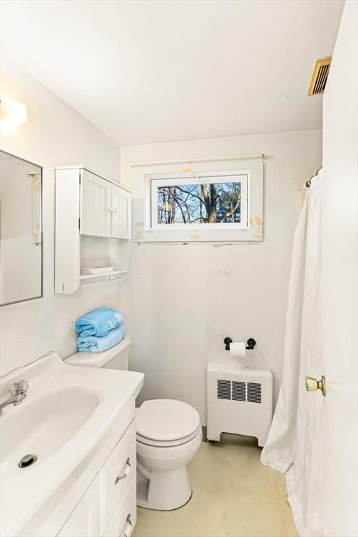 bathroom with vanity, toilet, and radiator