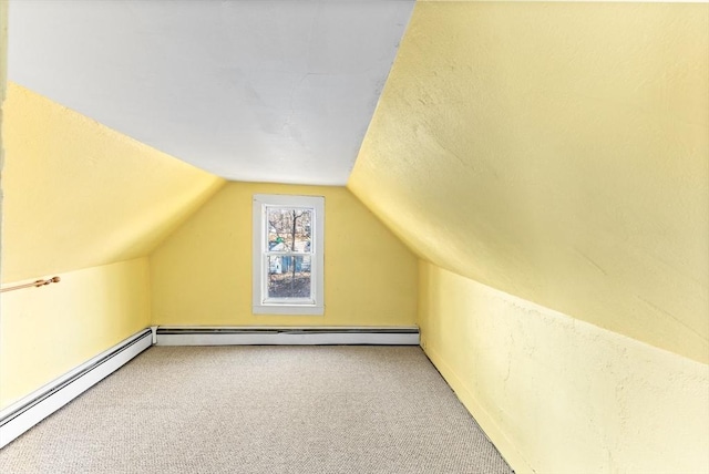 additional living space with carpet, a baseboard radiator, and vaulted ceiling