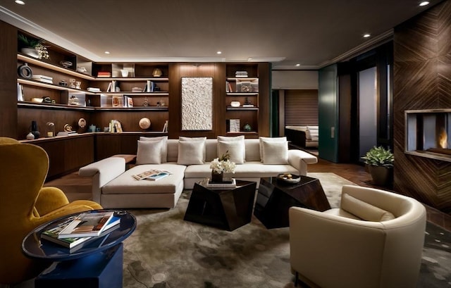 living area featuring ornamental molding, built in shelves, and recessed lighting