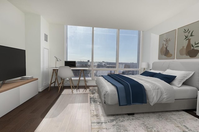 bedroom featuring wood finished floors and floor to ceiling windows