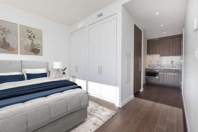 bedroom featuring dark wood finished floors, baseboards, and recessed lighting