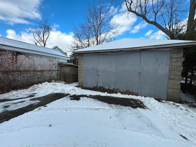 yard layered in snow with a garage and an outdoor structure