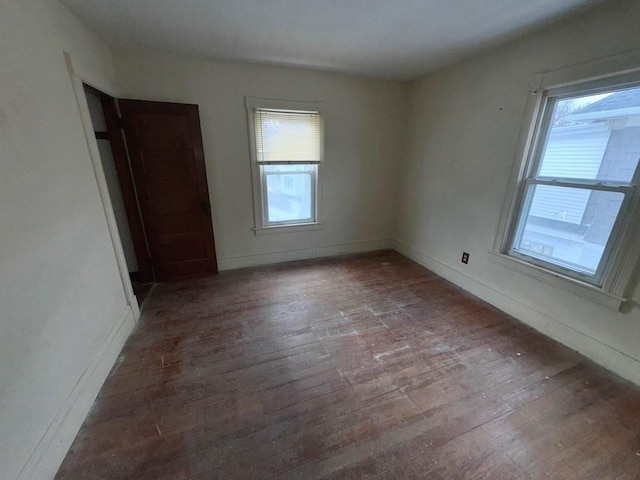 spare room with a wealth of natural light and hardwood / wood-style floors