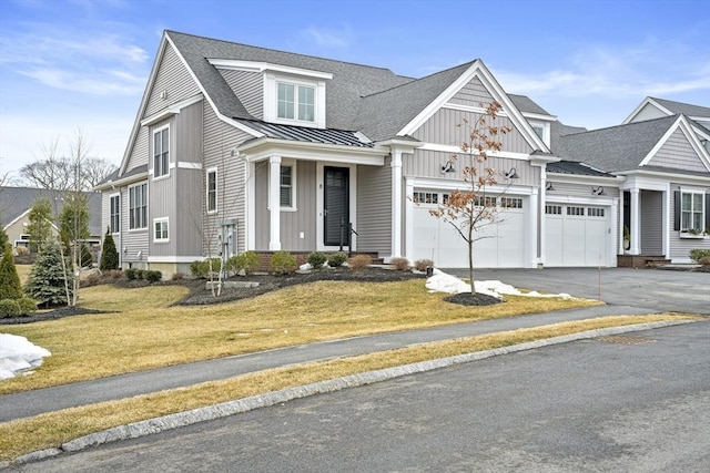 view of front of property with a shingled roof, a front yard, metal roof, driveway, and a standing seam roof