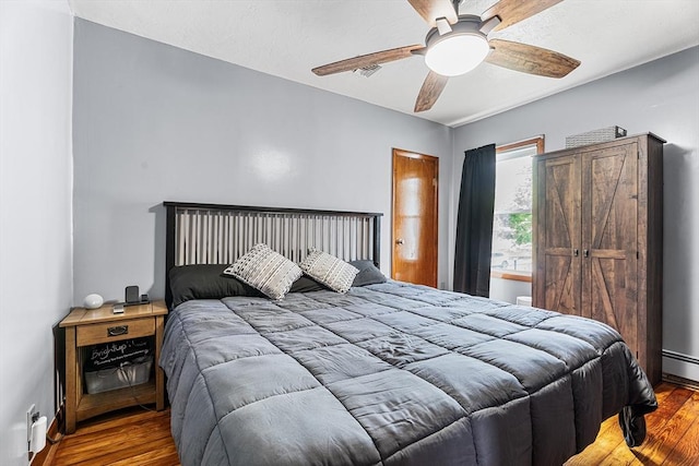 bedroom featuring wood finished floors, a ceiling fan, and baseboards
