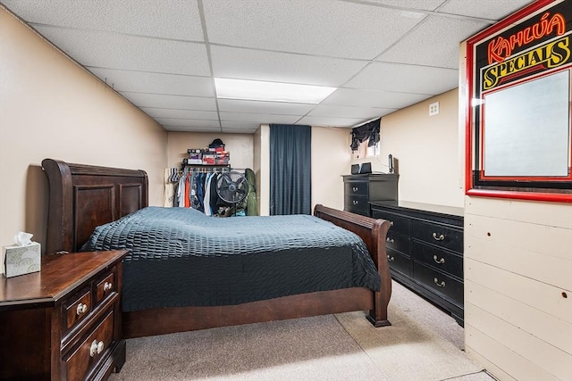 carpeted bedroom featuring a drop ceiling