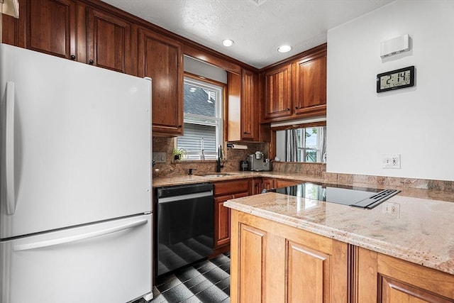 kitchen with freestanding refrigerator, dishwasher, backsplash, black electric stovetop, and a sink