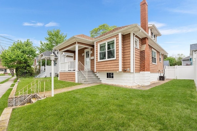 bungalow with a porch, a chimney, and stairs