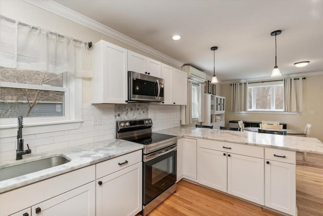 38 Rocky Hill Rd Unit B, Amesbury, MA 01913 - kitchen featuring appliances with stainless steel finishes, a sink, a peninsula, crown molding, and white cabinetry