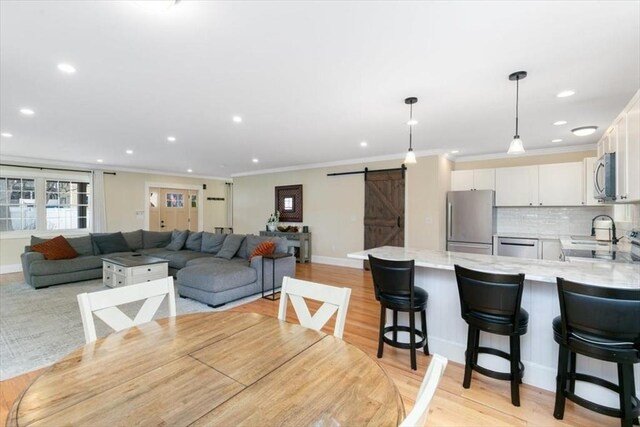 38 Rocky Hill Rd Unit B, Amesbury, MA 01913 - dining area with a barn door, recessed lighting, crown molding, light wood-style flooring, and baseboards