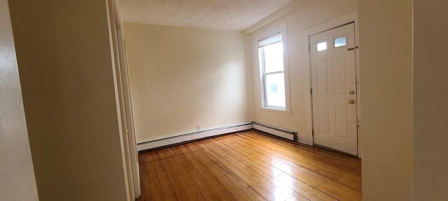 foyer entrance featuring hardwood / wood-style floors and a baseboard heating unit