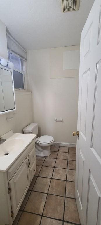 bathroom with tile patterned flooring, vanity, and toilet