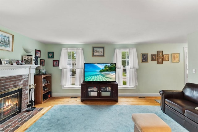 37 Railroad Ave, Whitman, MA 02382 - living area featuring a brick fireplace, wood finished floors, and baseboards