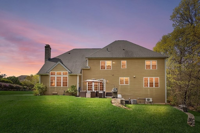 3 Emerson Way, Hopkinton, MA 01748 - back of property at dusk featuring outdoor lounge area, a chimney, a lawn, and roof with shingles