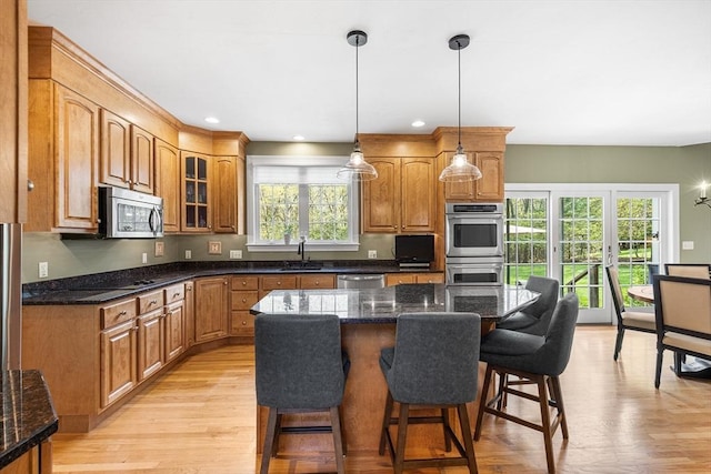 3 Emerson Way, Hopkinton, MA 01748 - kitchen with stainless steel appliances, a sink, a kitchen breakfast bar, glass insert cabinets, and pendant lighting