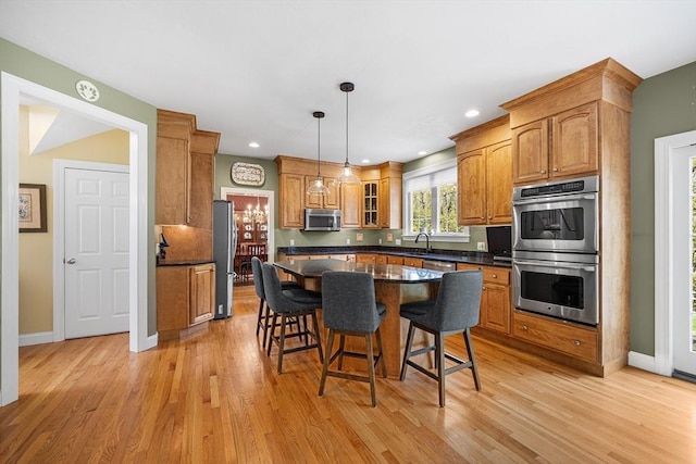 3 Emerson Way, Hopkinton, MA 01748 - kitchen with appliances with stainless steel finishes, dark countertops, a kitchen breakfast bar, light wood-type flooring, and recessed lighting