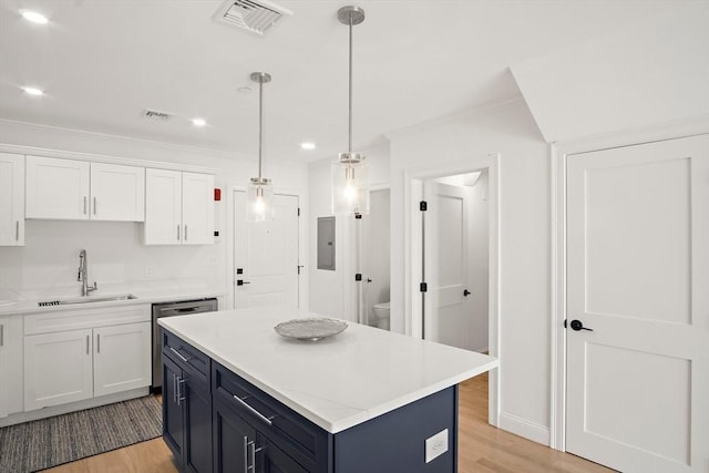 50 N Payne St Unit 2, Quincy, MA 02169 - kitchen featuring a sink, white cabinetry, crown molding, light wood finished floors, and decorative light fixtures