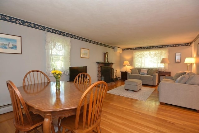 13 N Grove St, Foxboro, MA 02035 - dining space with light wood-style flooring, plenty of natural light, and a fireplace