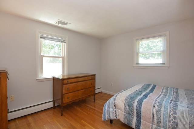 13 N Grove St, Foxboro, MA 02035 - bedroom featuring a baseboard radiator, multiple windows, baseboard heating, and light wood-style floors