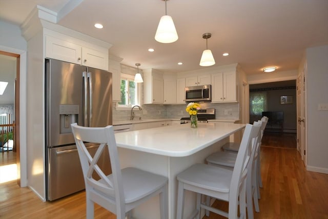 13 N Grove St, Foxboro, MA 02035 - kitchen featuring stainless steel appliances, light countertops, white cabinetry, backsplash, and light wood-type flooring