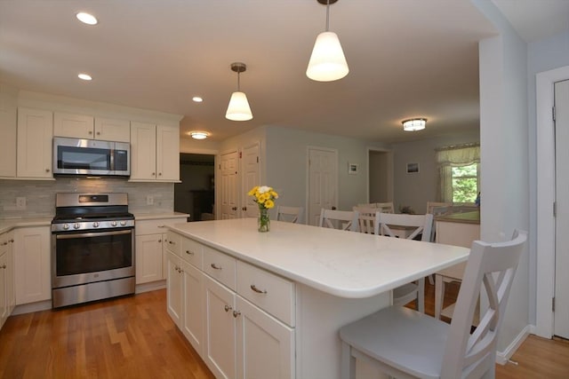13 N Grove St, Foxboro, MA 02035 - kitchen with stainless steel appliances, tasteful backsplash, light countertops, a kitchen bar, and recessed lighting