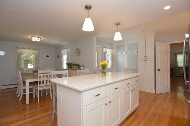 13 N Grove St, Foxboro, MA 02035 - kitchen featuring light wood-style flooring, white cabinetry, a center island, decorative light fixtures, and light countertops