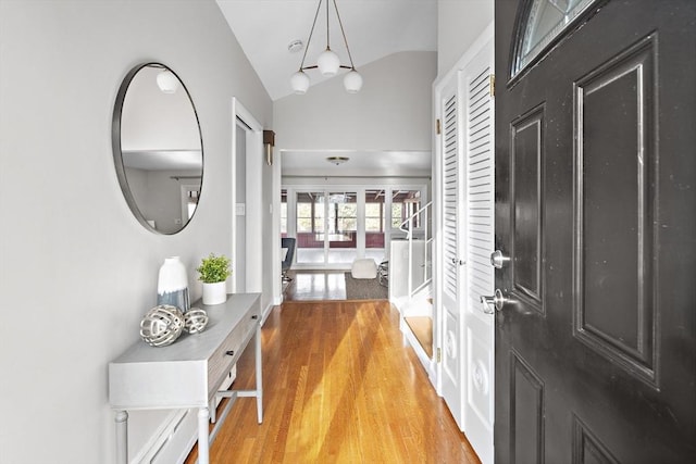 entrance foyer featuring hardwood / wood-style floors and vaulted ceiling