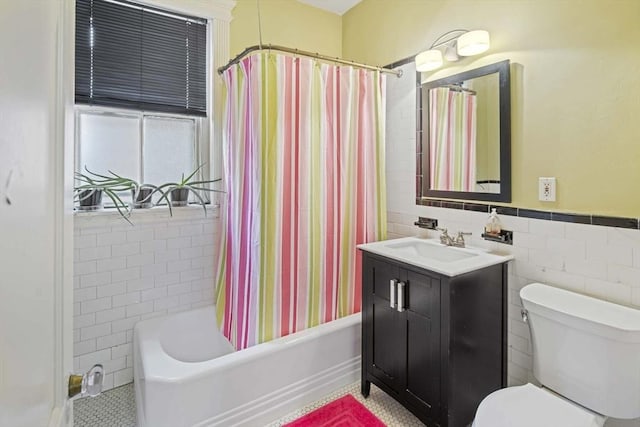 full bathroom featuring tile walls, vanity, toilet, and shower / bath combo with shower curtain