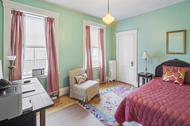 bedroom with radiator and light wood-type flooring