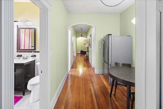 corridor with sink and hardwood / wood-style floors