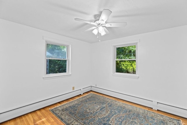 spare room with a baseboard heating unit, ceiling fan, baseboard heating, and wood finished floors