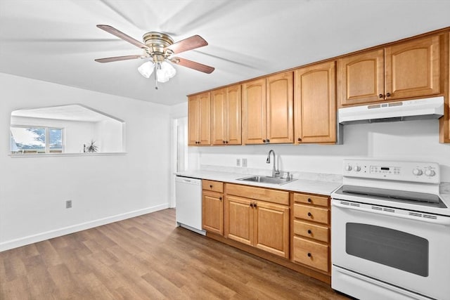 kitchen featuring light countertops, a sink, wood finished floors, white appliances, and under cabinet range hood