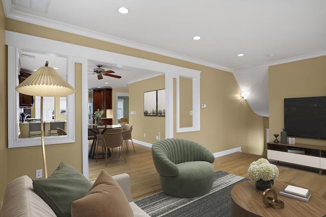 living room featuring light wood finished floors, recessed lighting, baseboards, and ornamental molding