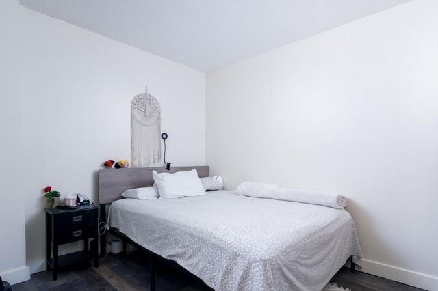 bedroom featuring baseboards and dark wood finished floors