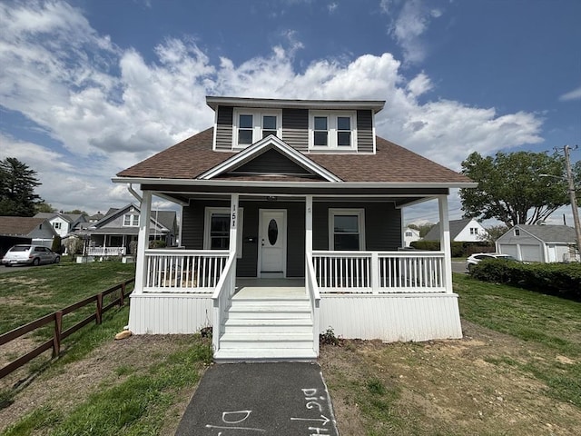 bungalow-style house featuring roof with shingles and covered porch